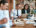 employees at a table working in front of a laptop